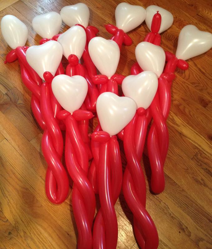 A cluster of red and white balloon sculptures resembling balloons with heart-shaped tops